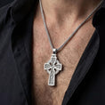Load image into Gallery viewer, Polished silver trinity knot cross necklace worn on chest highlighting spiritual symbolism
