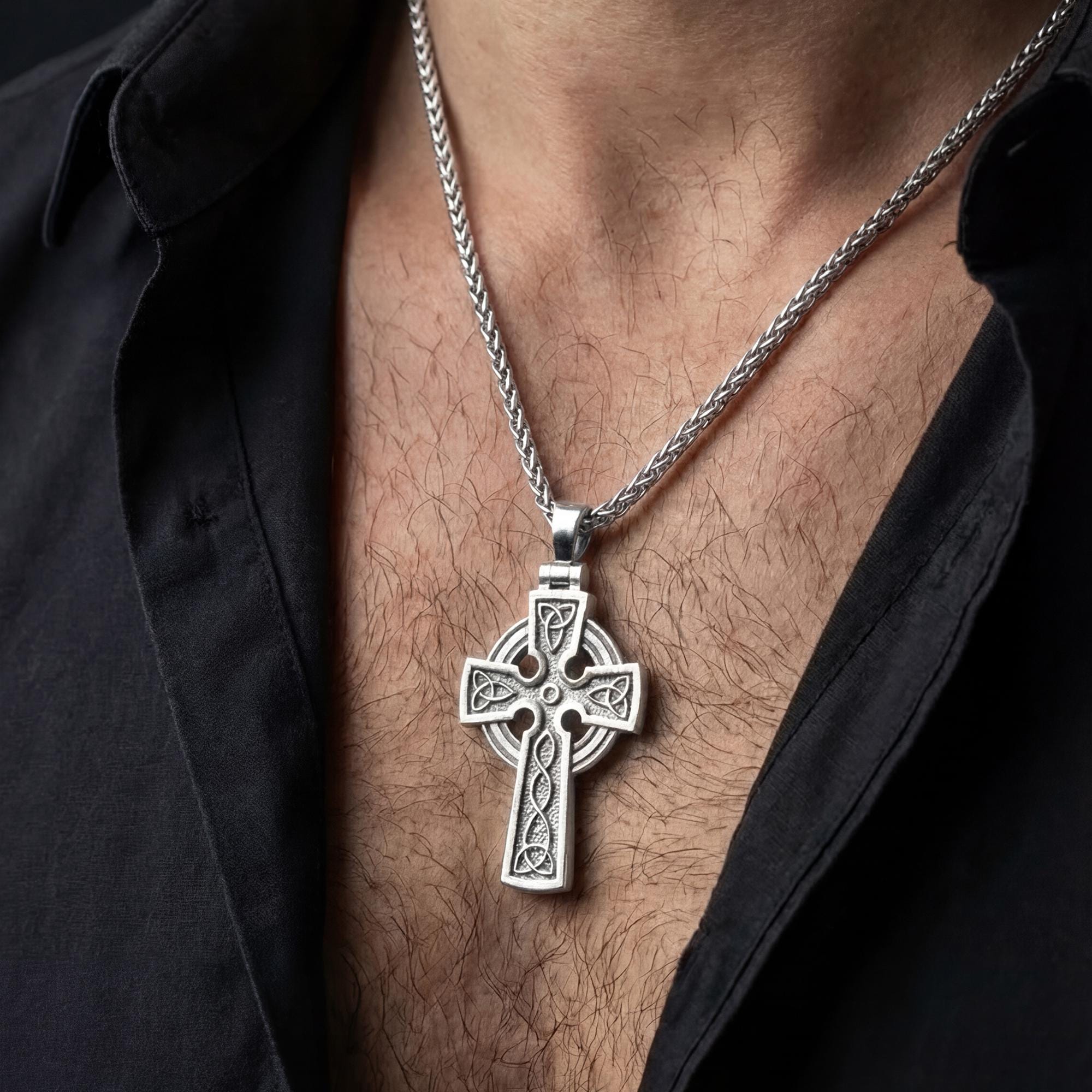 Polished silver trinity knot cross necklace worn on chest highlighting spiritual symbolism