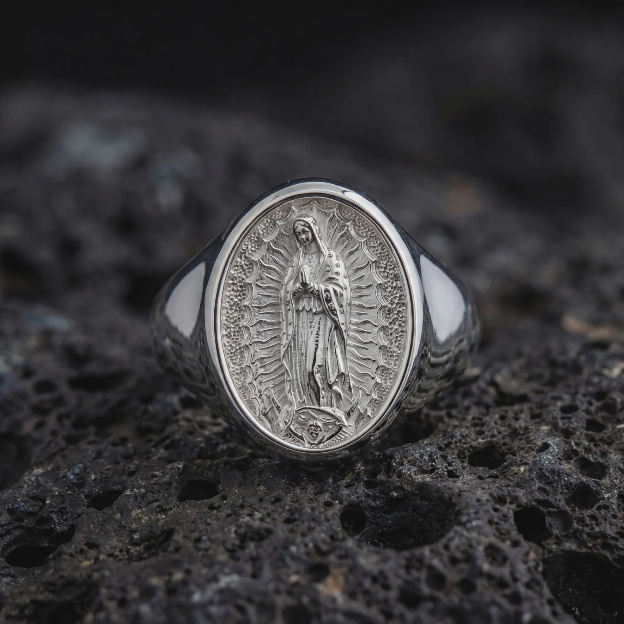 Polished silver Guadalupe Marian signet ring showcasing detailed religious relief on volcanic stone