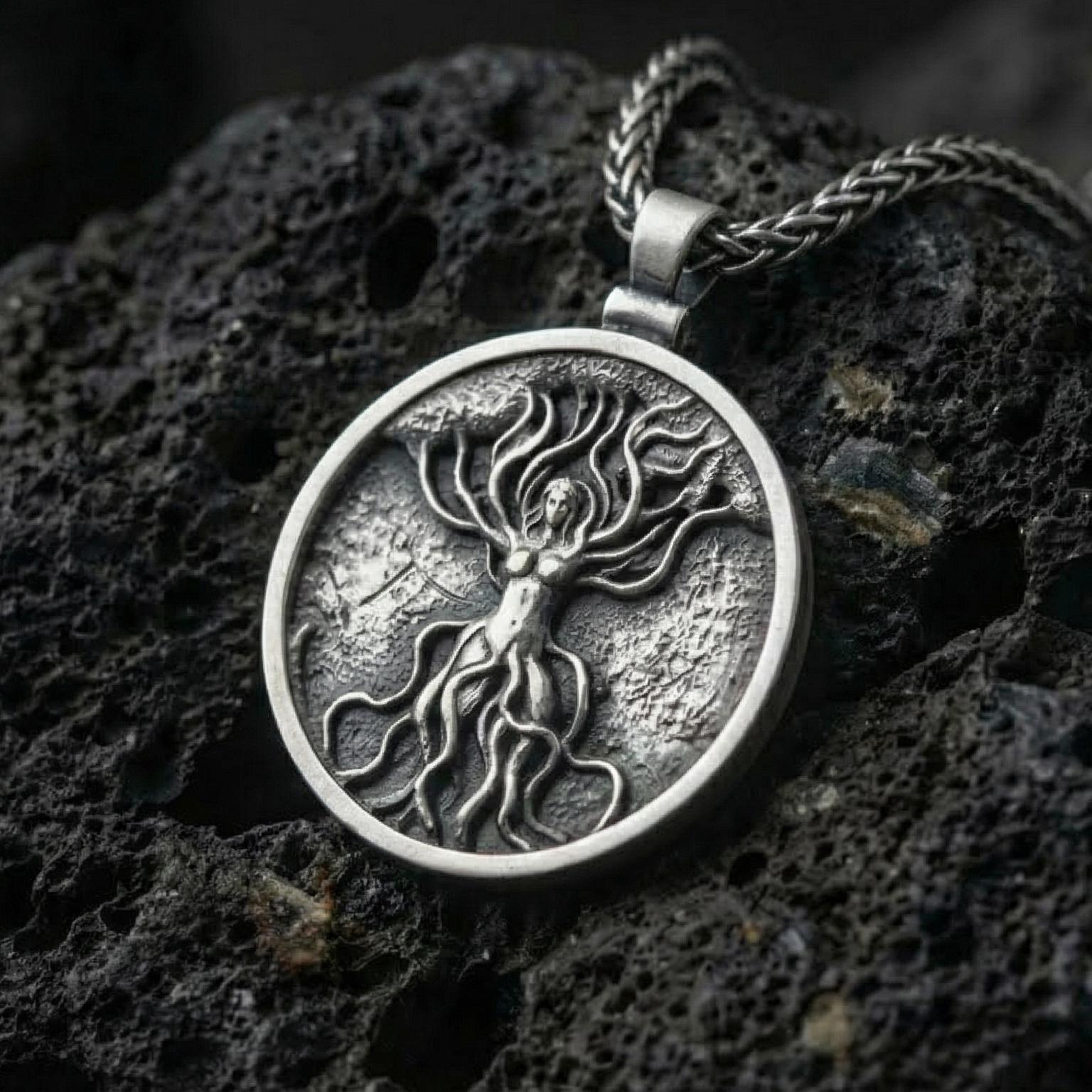 Oxidized tree of life goddess pendant necklace photographed on volcanic rock with feminine nature spirit relief