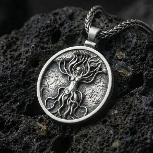 Oxidized tree of life goddess pendant necklace photographed on volcanic rock with feminine nature spirit relief