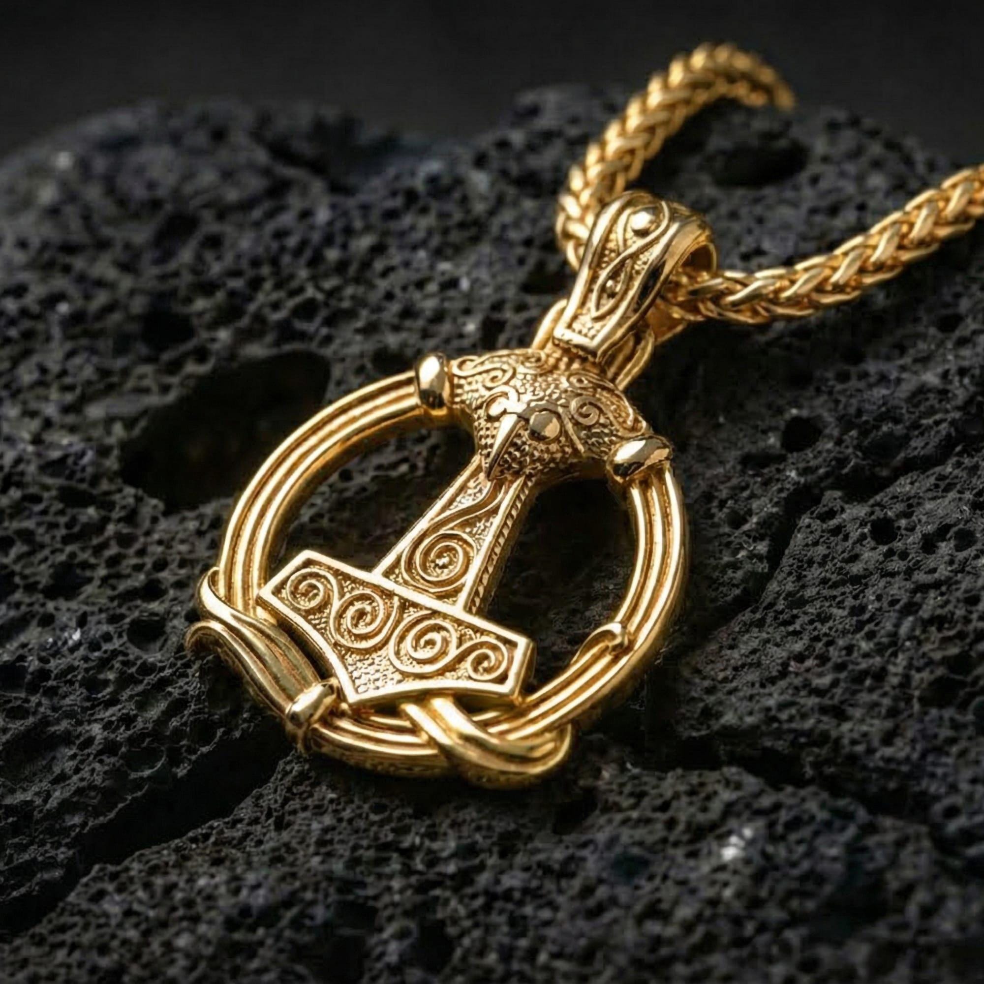 Gold plated Thor’s Hammer pendant showcased on volcanic rock as a symbol of power, protection, and strength