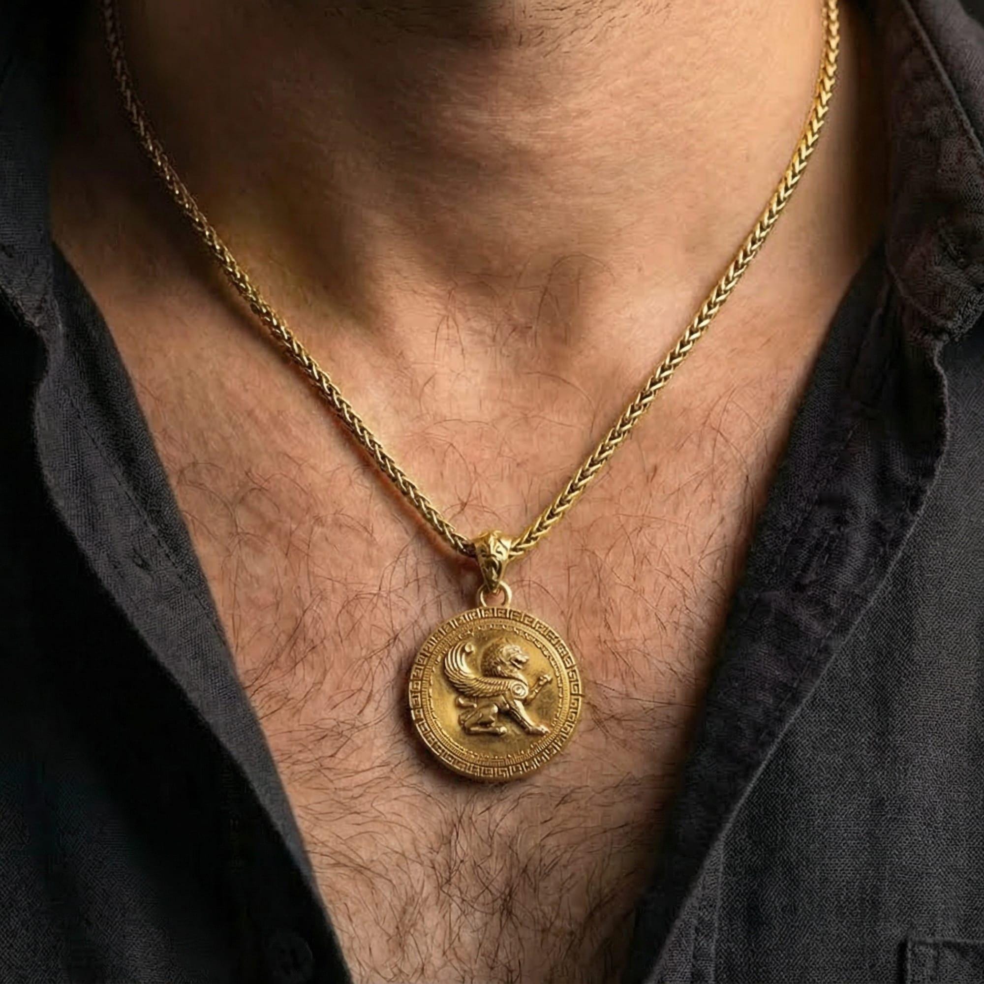 Gold plated winged lion pendant necklace worn by man as bold mythic statement jewelry