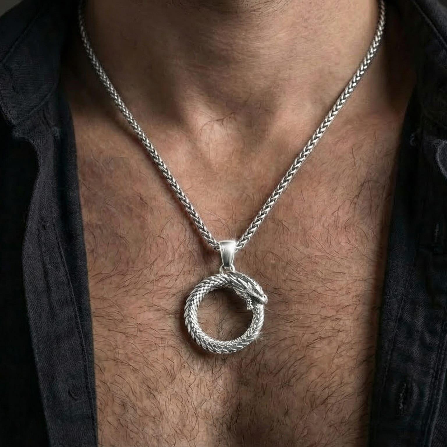 Polished silver ouroboros snake necklace worn on chest emphasizing ancient mythology and transformation