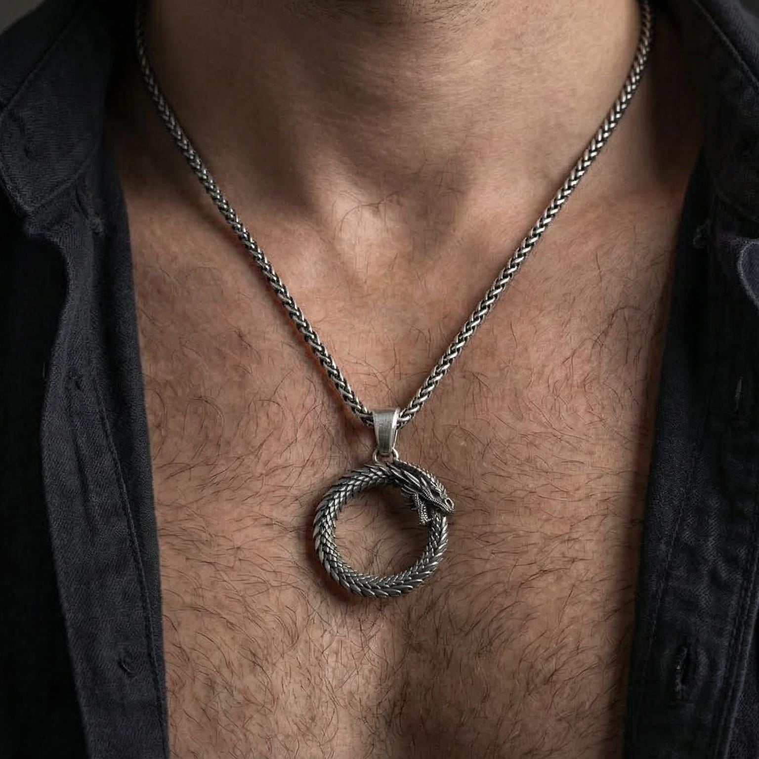 Oxidized ouroboros serpent pendant necklace worn on male model as a symbol of rebirth and eternity