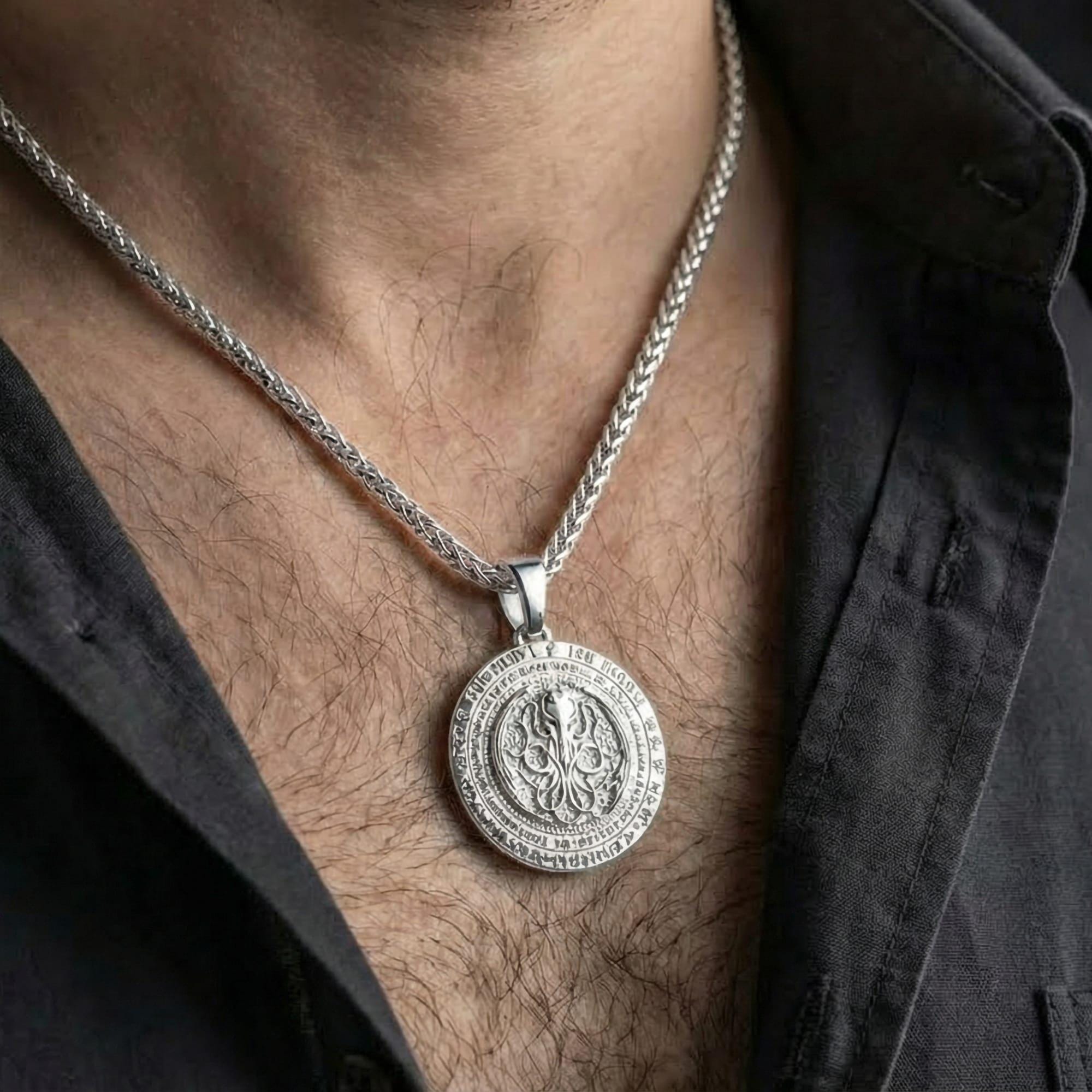 Polished silver Lovecraftian Cthulhu amulet worn on chest highlighting cosmic horror symbolism