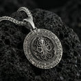 Load image into Gallery viewer, Oxidized Cthulhu pendant necklace photographed on volcanic rock with engraved Lovecraftian octopus sigil and eldritch detail

