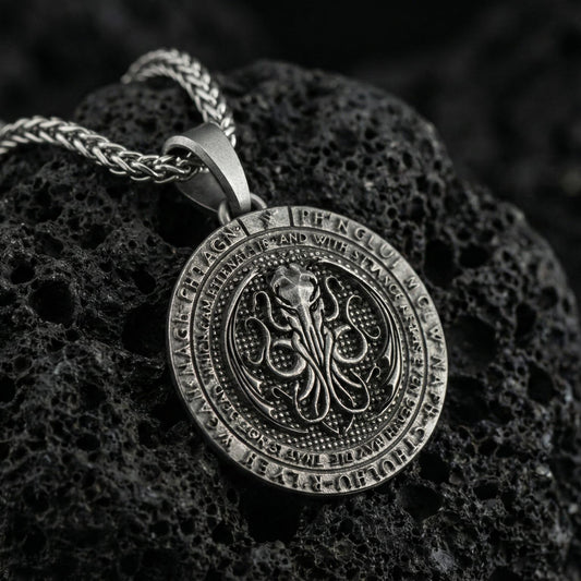 Oxidized Cthulhu pendant necklace photographed on volcanic rock with engraved Lovecraftian octopus sigil and eldritch detail