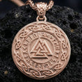 Load image into Gallery viewer, Rose gold plated Norse Valknut rune pendant necklace presented on volcanic rock surface with dark Viking myth aesthetic
