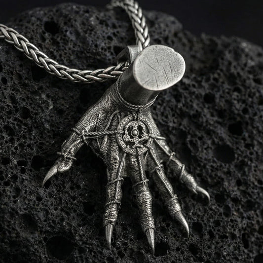 Oxidized Hand of Maliketh pendant necklace photographed on volcanic rock with detailed clawed hand relief and gothic texture
