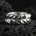 Load image into Gallery viewer, Polished silver faceted mens wedding band displayed on volcanic stone background highlighting precision-cut geometric surfaces and clean symmetry
