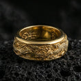 Load image into Gallery viewer, Gold plated phoenix fidget wedding band showcased on volcanic rock as a symbol of immortality, strength, and renewal
