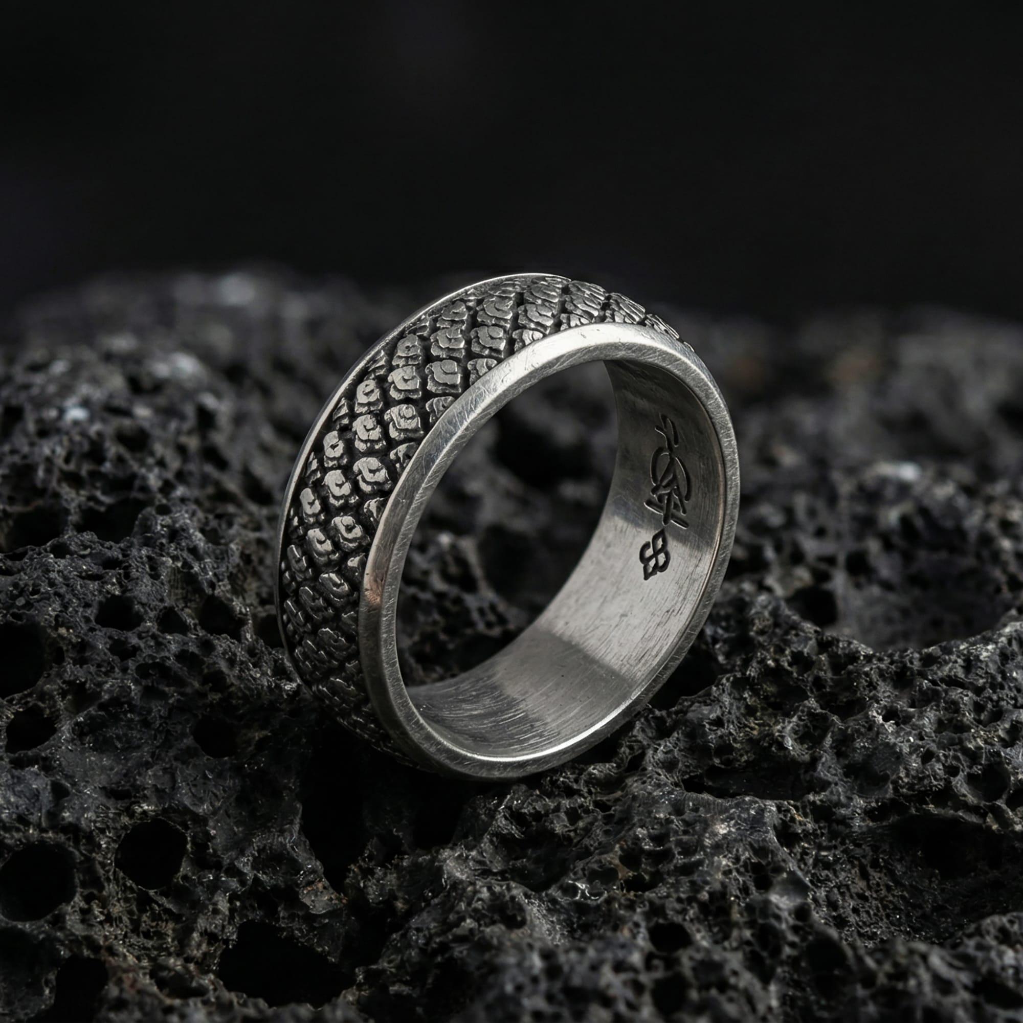 Oxidized Japanese cloud motif band ring photographed on volcanic rock, featuring traditional swirling “kumo” wind-and-cloud relief with artisan-carved texture