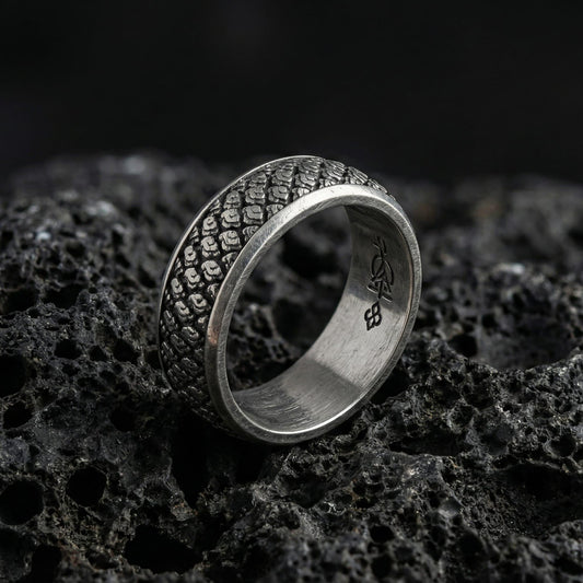 Oxidized Japanese cloud motif band ring photographed on volcanic rock, featuring traditional swirling “kumo” wind-and-cloud relief with artisan-carved texture