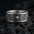 Load image into Gallery viewer, Oxidized lion head wedding band ring photographed on volcanic rock with raised feline crest centerpiece and medieval-inspired engraved details
