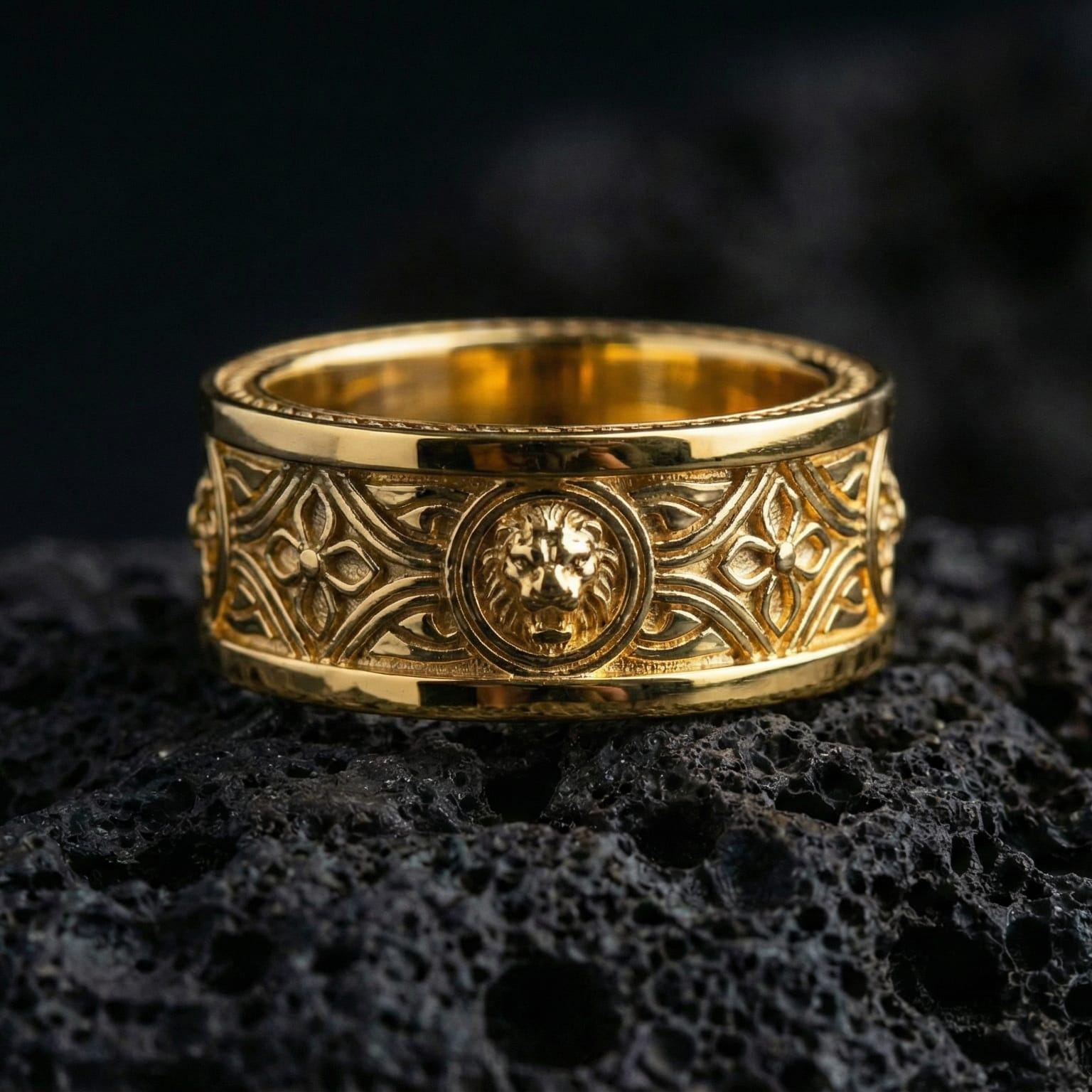 Gold plated lion head signet-style band ring showcased on volcanic rock emphasizing regal guardian symbolism and heritage ring aesthetic