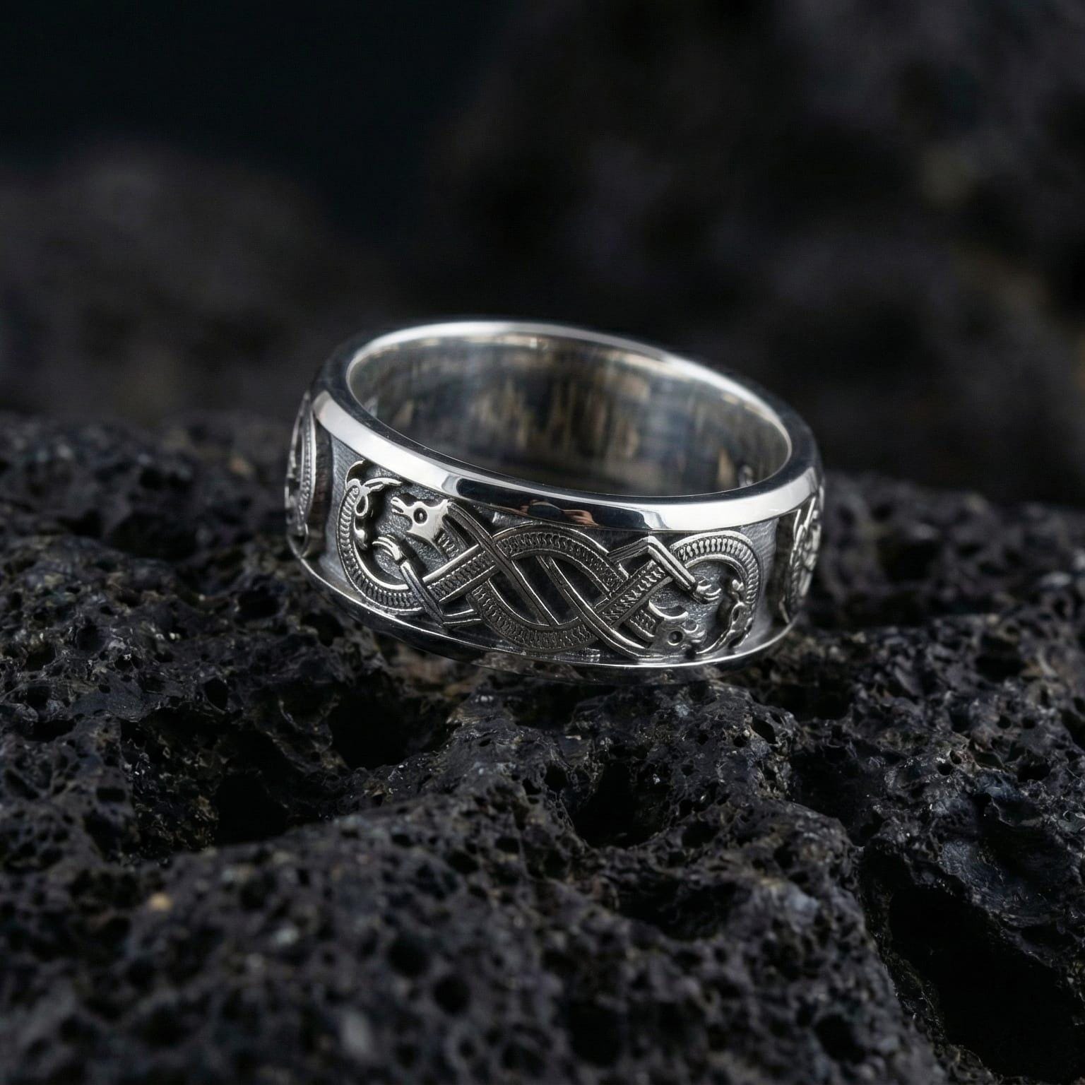 White GoldSlavic dragon band ring on volcanic stone showcasing intricate intertwined dragon design and clean unisex profile