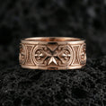 Load image into Gallery viewer, Rose Gold Knights Hospitaller Maltese cross wedding band showcased on volcanic rock with heritage-inspired fleur de lis pattern and bold masculine profile
