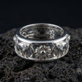 Load image into Gallery viewer, Polished silver spinning elephant wedding band displayed on volcanic stone background highlighting smooth comfort-fit edges and detailed animal relief
