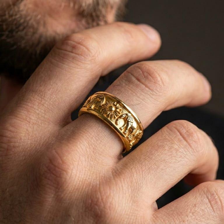 Gold plated elephant wedding band ring worn by man as a bold luck and protection symbol, spinner fidget style with detailed sun centerpiece