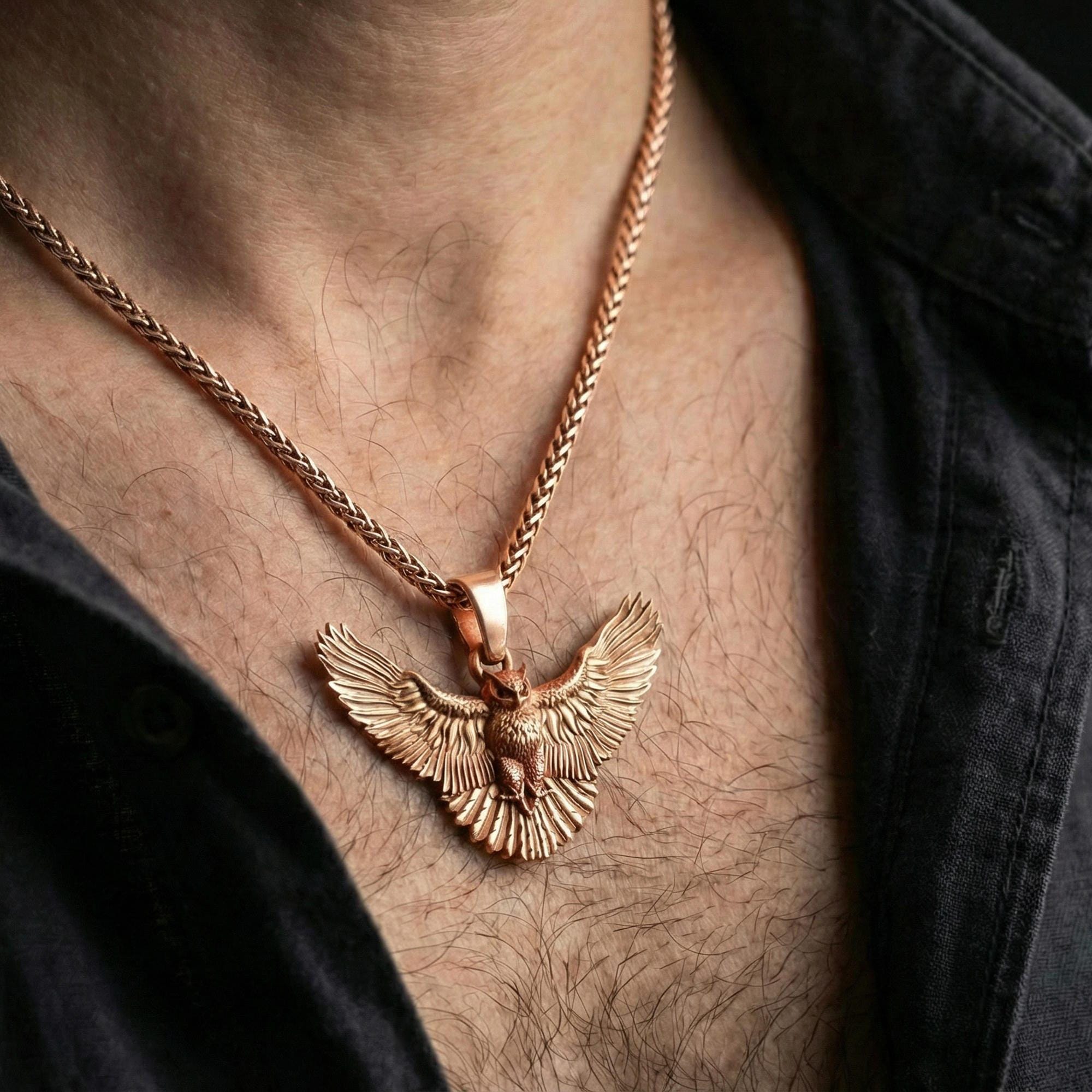 Rose gold plated owl pendant necklace worn on neck, lifestyle composition with dark outfit, crisp feather texture