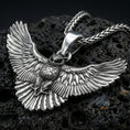 Load image into Gallery viewer, Polished silver owl necklace pendant on black volcanic stone background, crisp feather detailing, high-end product shot

