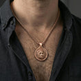 Load image into Gallery viewer, Rose gold plated Zeus pendant necklace worn on neck, lifestyle composition with dark clothing, crisp medallion silhouette
