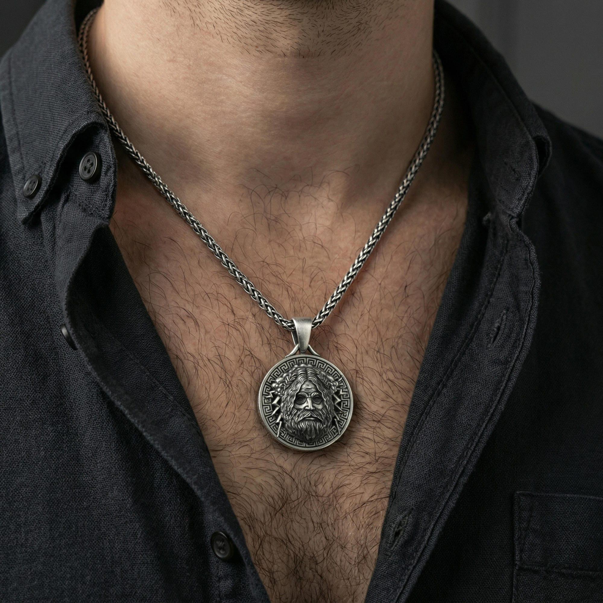 Oxidized Zeus pendant necklace worn on neck, lifestyle close-up on dark outfit, Greek myth medallion centered