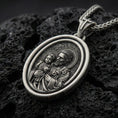 Load image into Gallery viewer, Oxidized Saint Joseph rotating pendant on textured volcanic rock, macro close-up, Catholic medallion with halo detail, premium studio lighting
