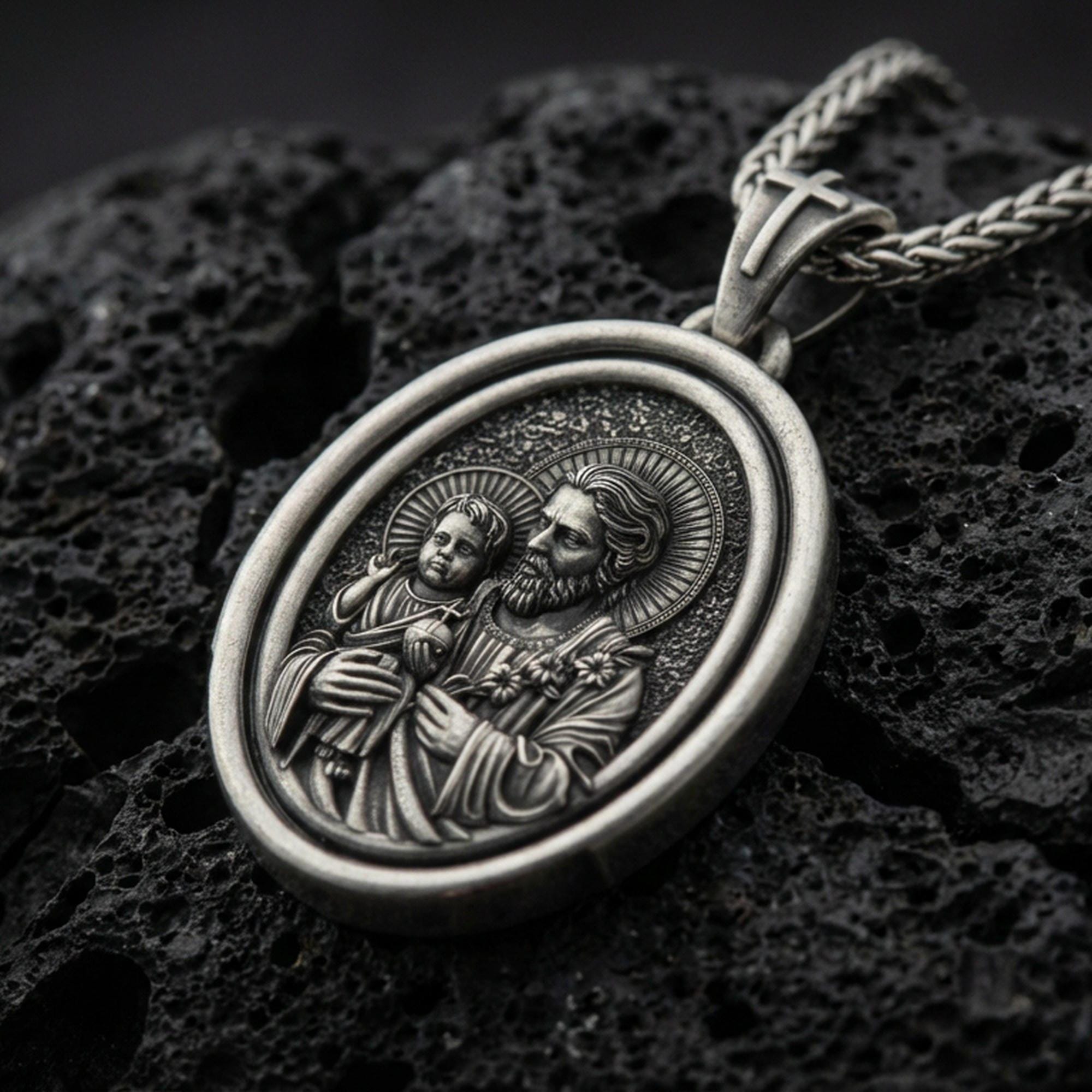 Oxidized Saint Joseph rotating pendant on textured volcanic rock, macro close-up, Catholic medallion with halo detail, premium studio lighting