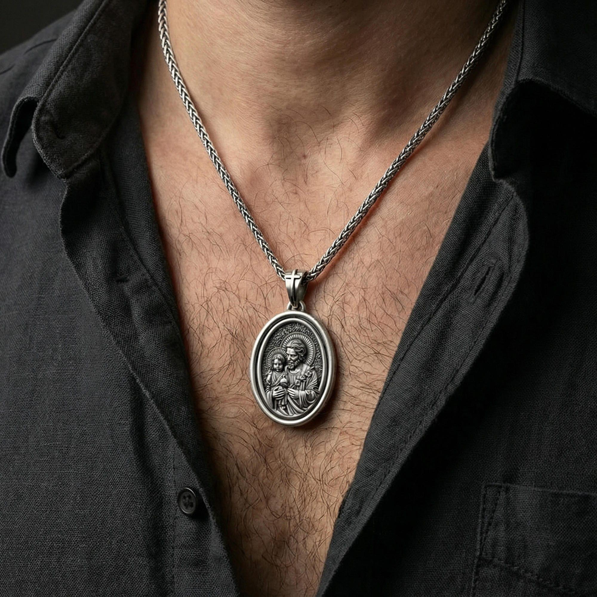 Oxidized Saint Joseph rotating pendant necklace worn on neck, lifestyle close-up on dark outfit, oval medallion centered