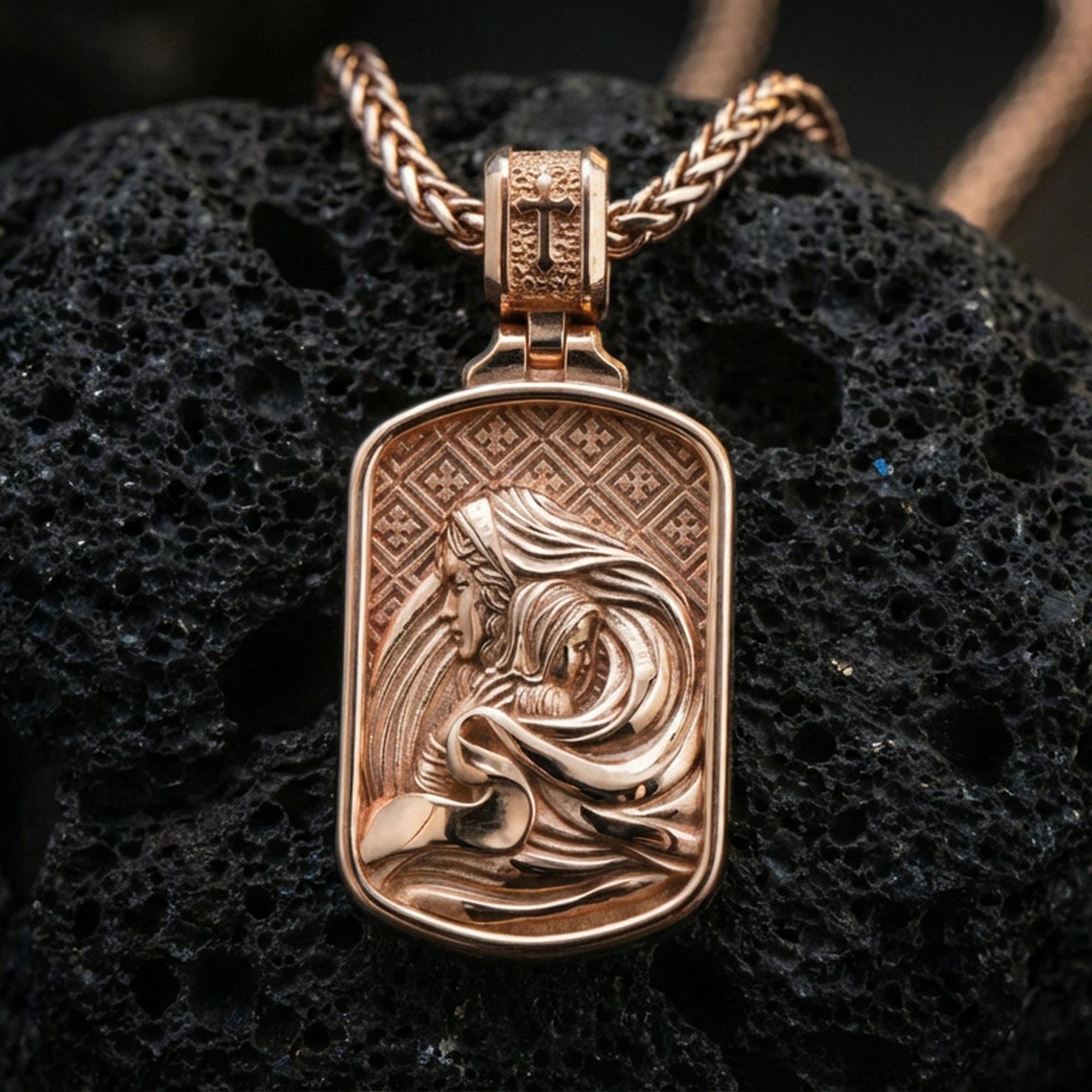 Rose gold plated Christian Mary and Child pendant on volcanic rock, premium macro product photo, sharp relief and smooth bezel edge