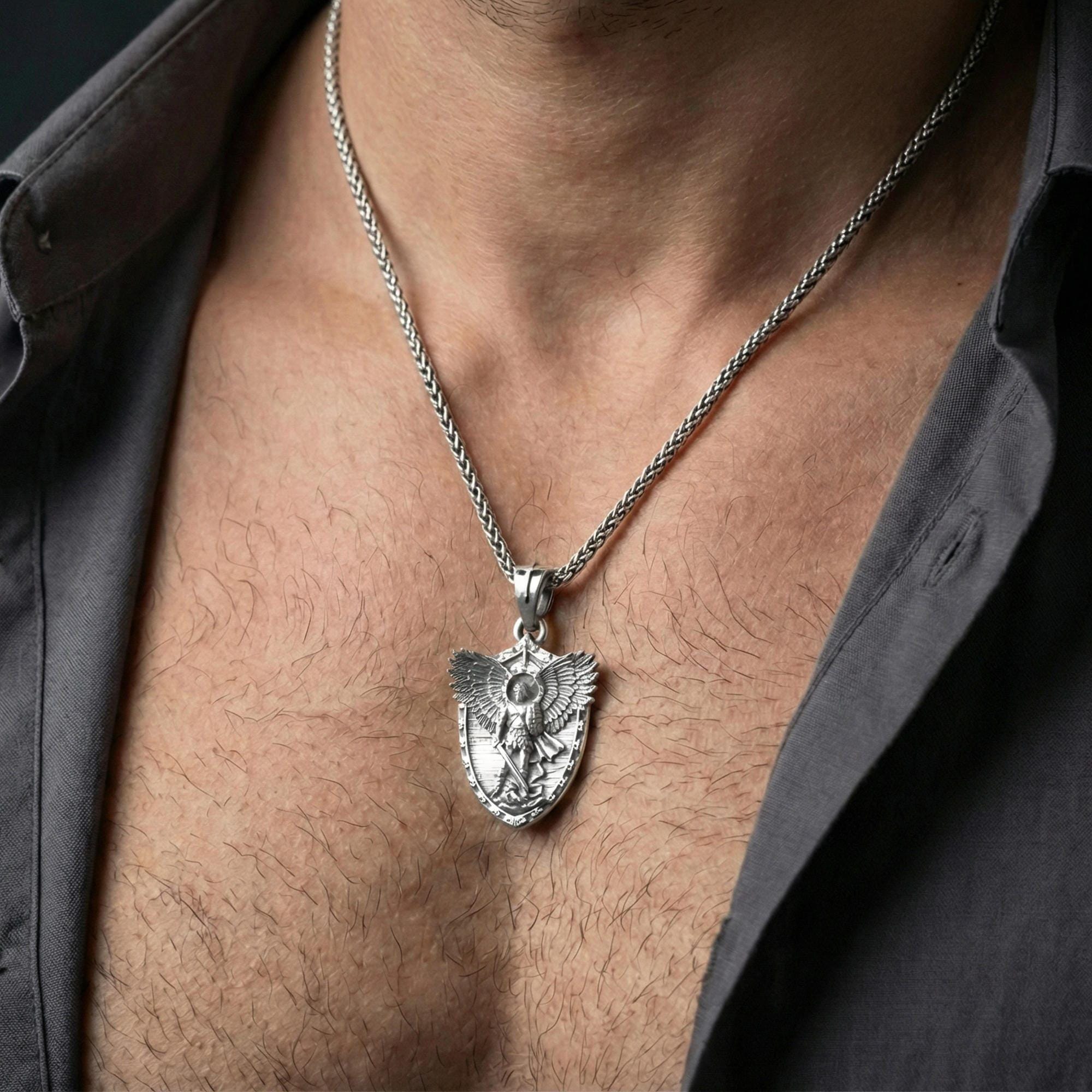 Polished silver Archangel Michael pendant on chain worn on neck, natural lifestyle framing, wings and shield clearly visible