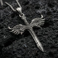 Load image into Gallery viewer, Oxidized Archangel Michael sword pendant on textured volcanic rock, macro close-up, winged crossguard detail, premium studio lighting
