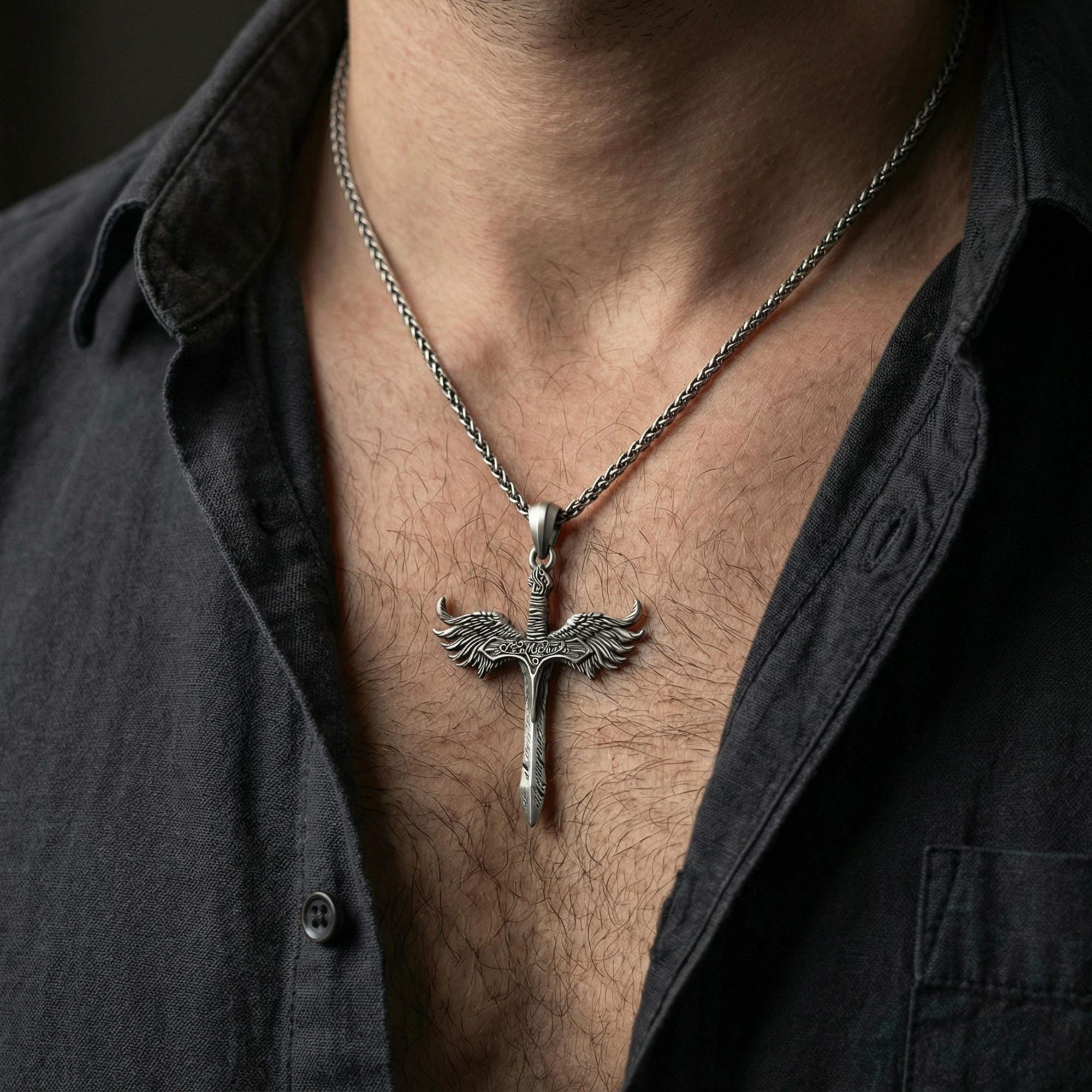 Oxidized Archangel Michael sword pendant necklace worn on neck, lifestyle close-up on dark outfit, winged sword centered