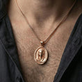 Load image into Gallery viewer, Rose gold plated Veiled Madonna pendant necklace worn on neck, lifestyle composition with dark clothing, crisp oval medallion silhouette

