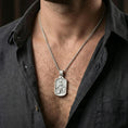 Load image into Gallery viewer, Polished silver Saint Roch dogtag pendant on chain worn on neck, natural lifestyle framing, saint and dog relief clearly visible
