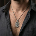 Load image into Gallery viewer, Oxidized Saint Roch dog tag pendant necklace worn on neck, lifestyle close-up on dark outfit, rectangular pendant centered
