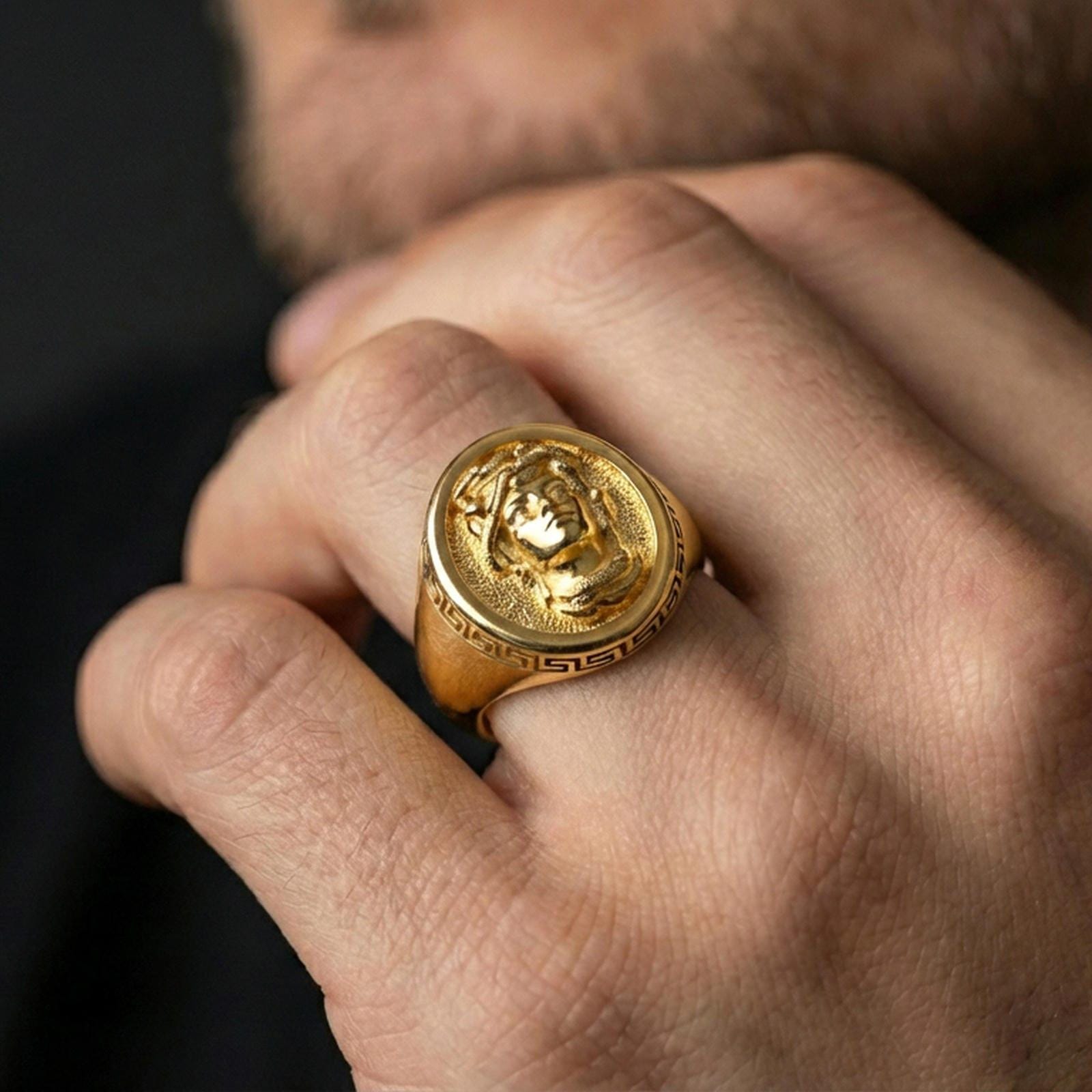 Gold plated Medusa signet ring worn on hand, ancient Greek inspired protective statement jewelry style