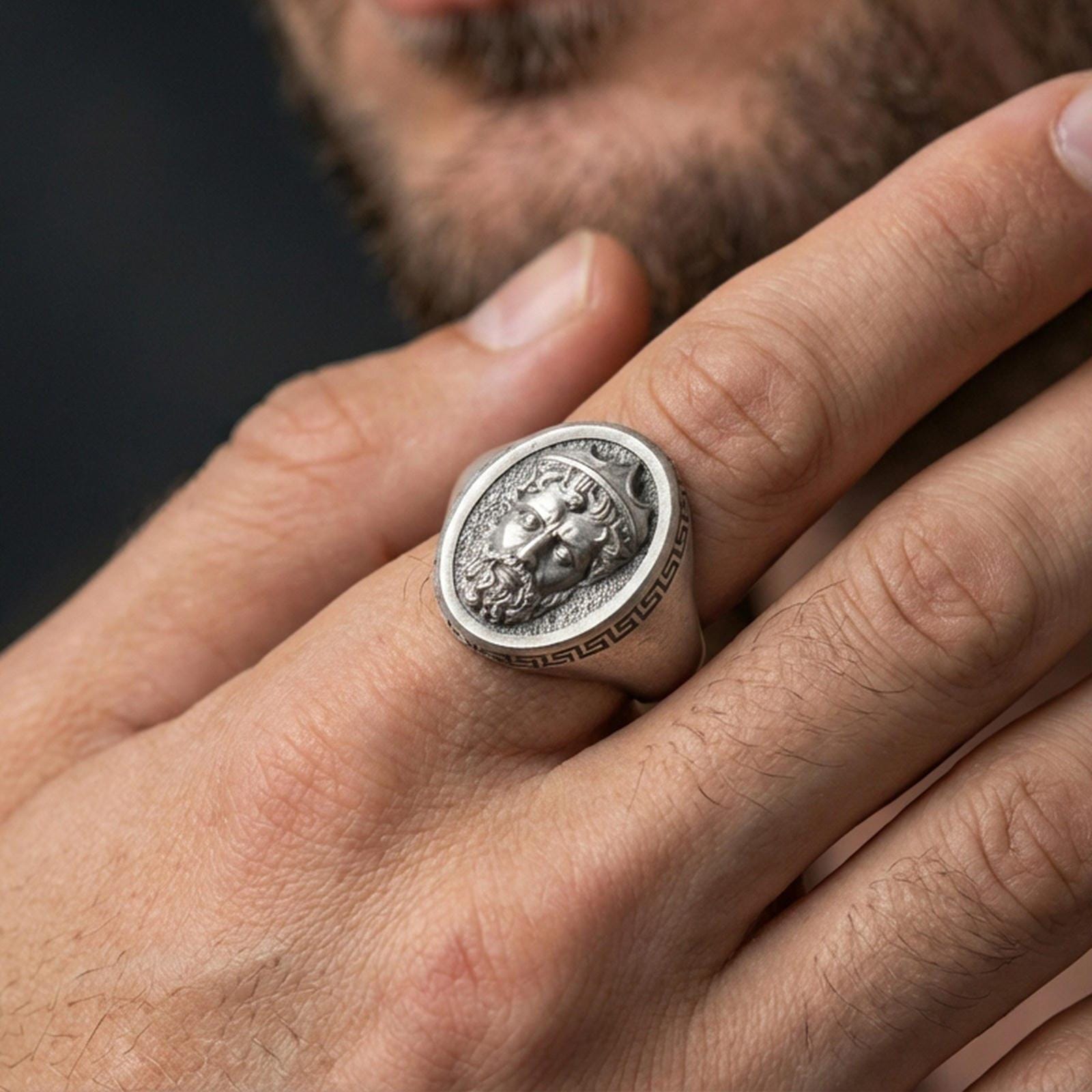 Oxidized Poseidon ring worn on finger, bold Greek mythology signet style, masculine statement jewelry close-up