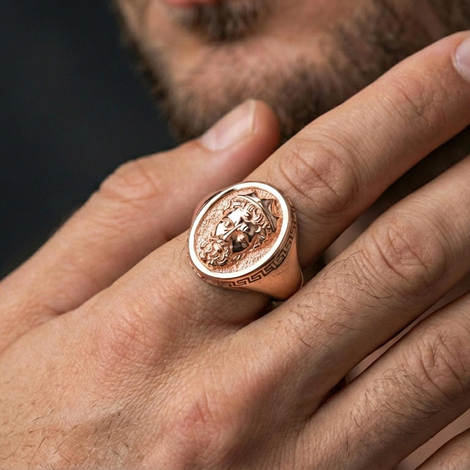 Rose gold plated Poseidon ring on hand, close-up lifestyle framing, detailed king portrait signet, elegant myth jewelry aesthetic