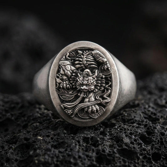 Oxidized: Oxidized sterling silver signet ring with detailed oni/dragon relief on volcanic rock, macro studio shot