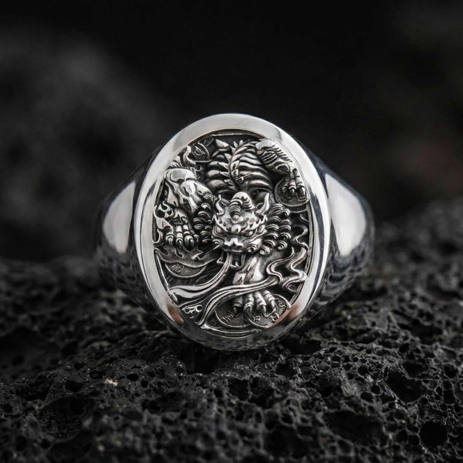 Polished Silver: Polished sterling silver signet ring with intricate Japanese guardian relief on volcanic rock, close-up detail