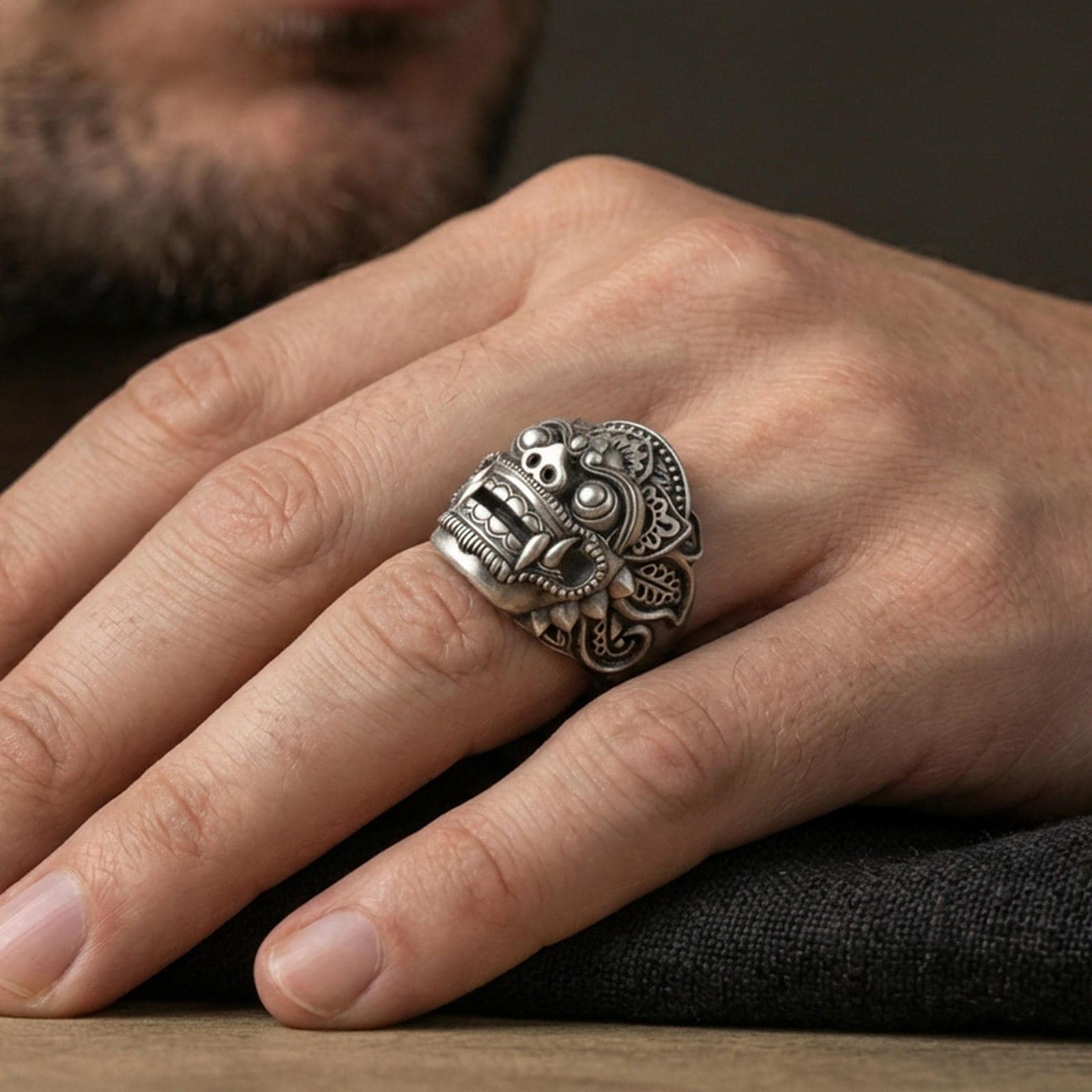 Balinese Barong god sterling silver ring in an oxidized finish worn on finger, detailed guardian mask relief, lifestyle hand close-up