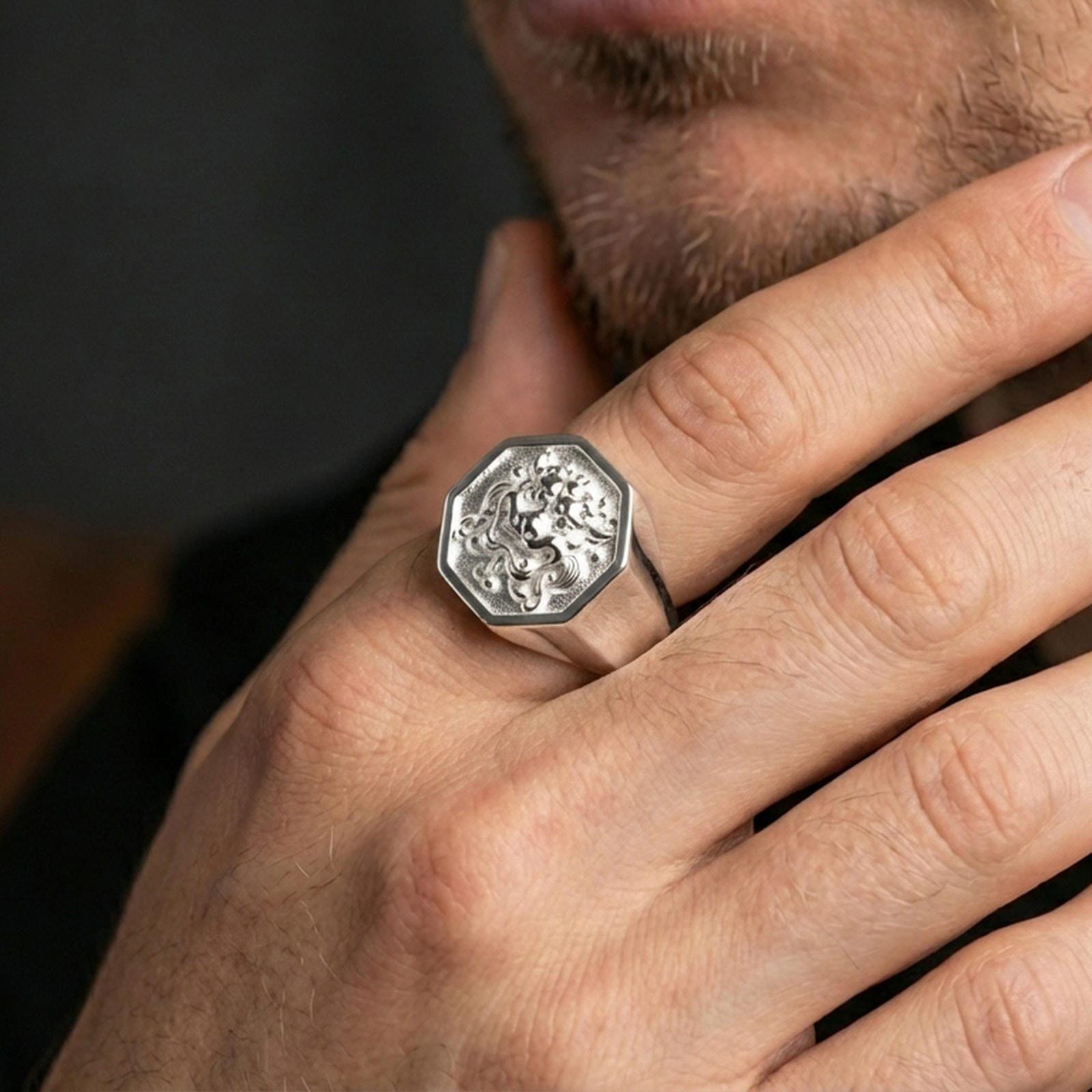 Octagon Foo Dog signet ring in polished silver finish on finger, sharp guardian lion details, natural lifestyle wear shot