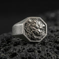 Load image into Gallery viewer, Octagon sterling silver Foo Dog signet ring in an oxidized finish on volcanic rock, Chinese guardian lion relief, macro studio product shot
