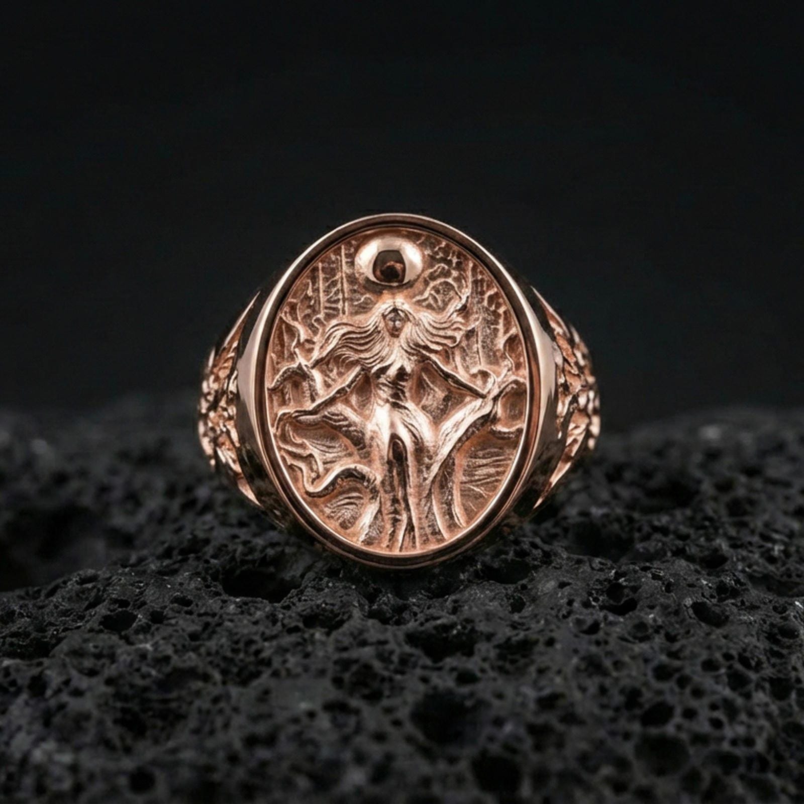 Freya Viking ring in a rose gold plated finish on volcanic rock, ornate Norse goddess Freyja engraving detail, luxury studio close-up