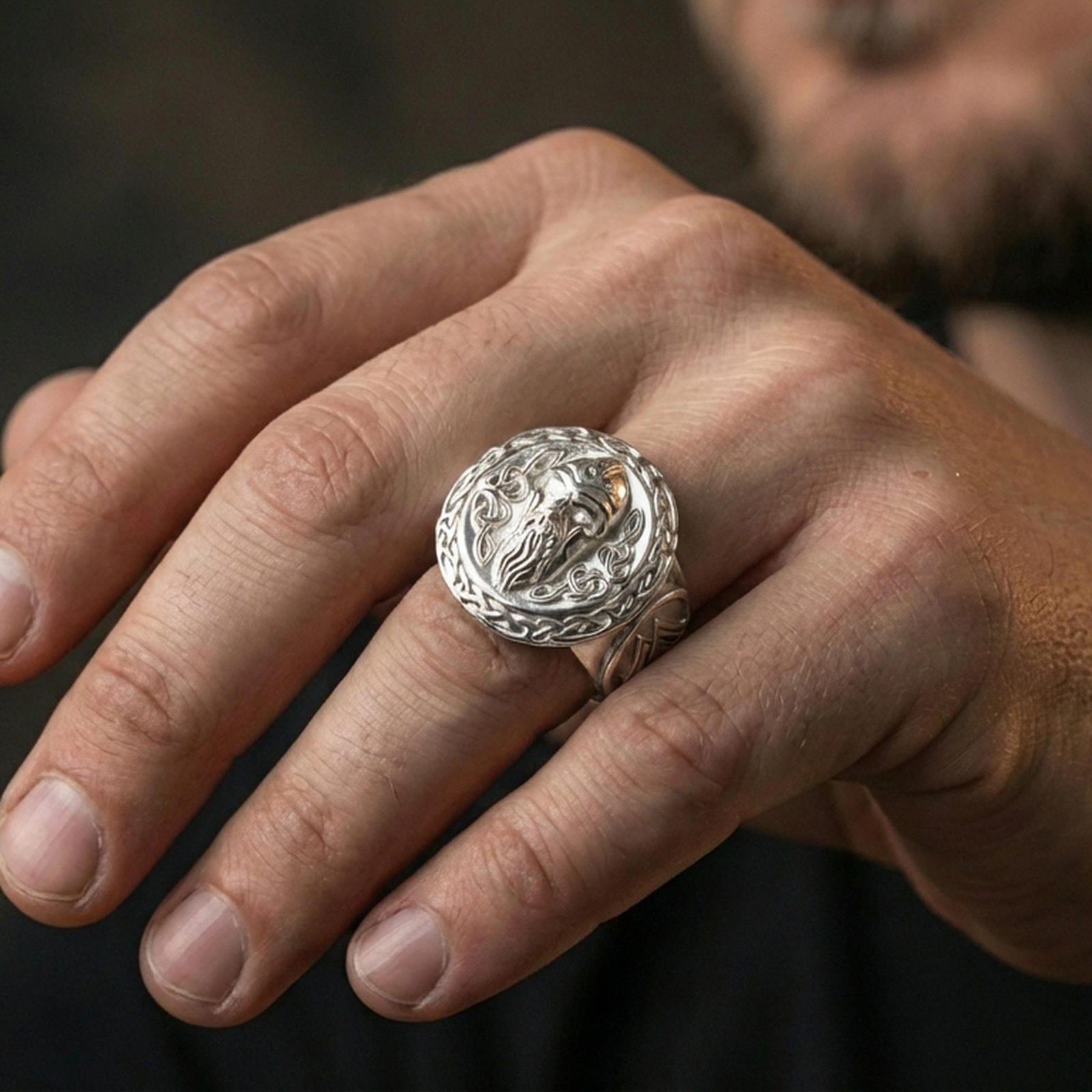 Odin ring in polished silver finish on finger, Norse mythology warrior face signet, natural lifestyle wear shot