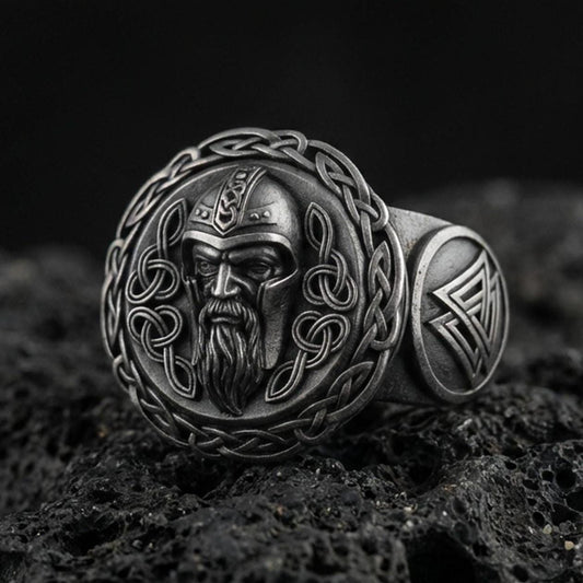 Odin the All-Father sterling silver ring in an oxidized finish on volcanic rock, Viking warrior portrait with Celtic knot border, macro studio product shot