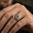 Load image into Gallery viewer, Oval Odin Norse god signet ring in an oxidized finish worn on finger, bearded portrait detail visible, lifestyle hand close-up
